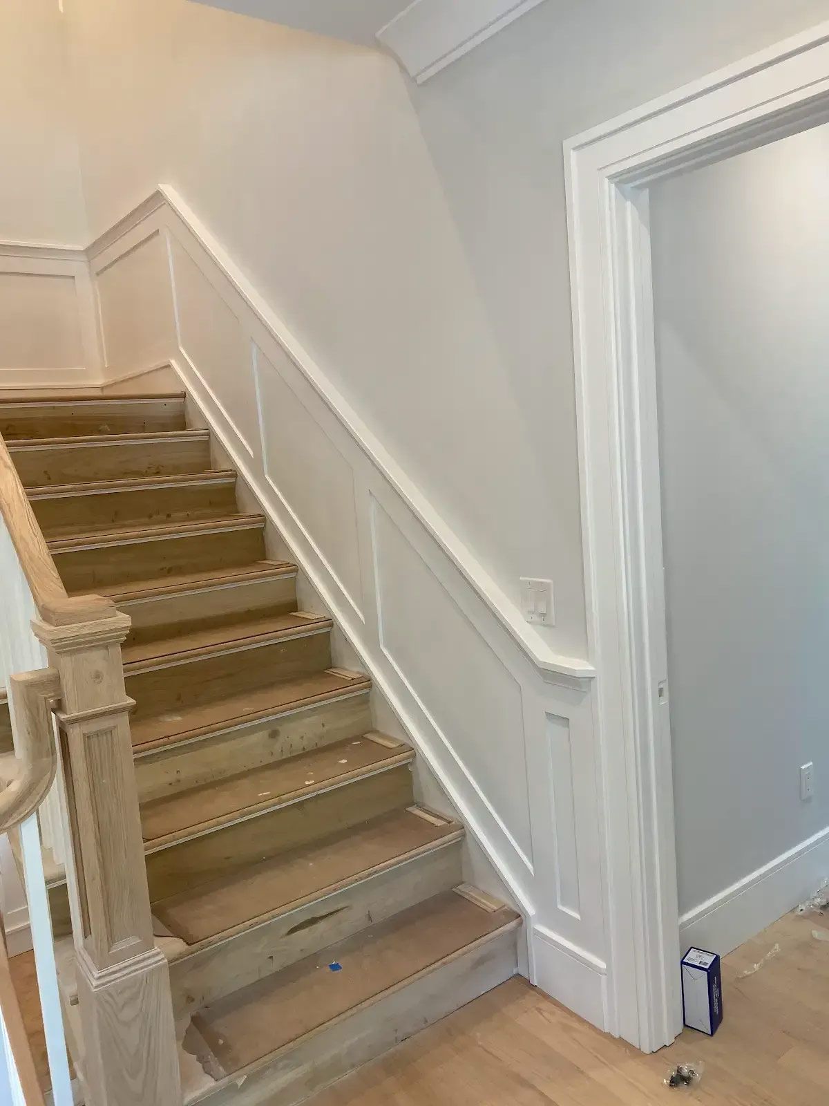A wooden staircase with a white railing in a house
