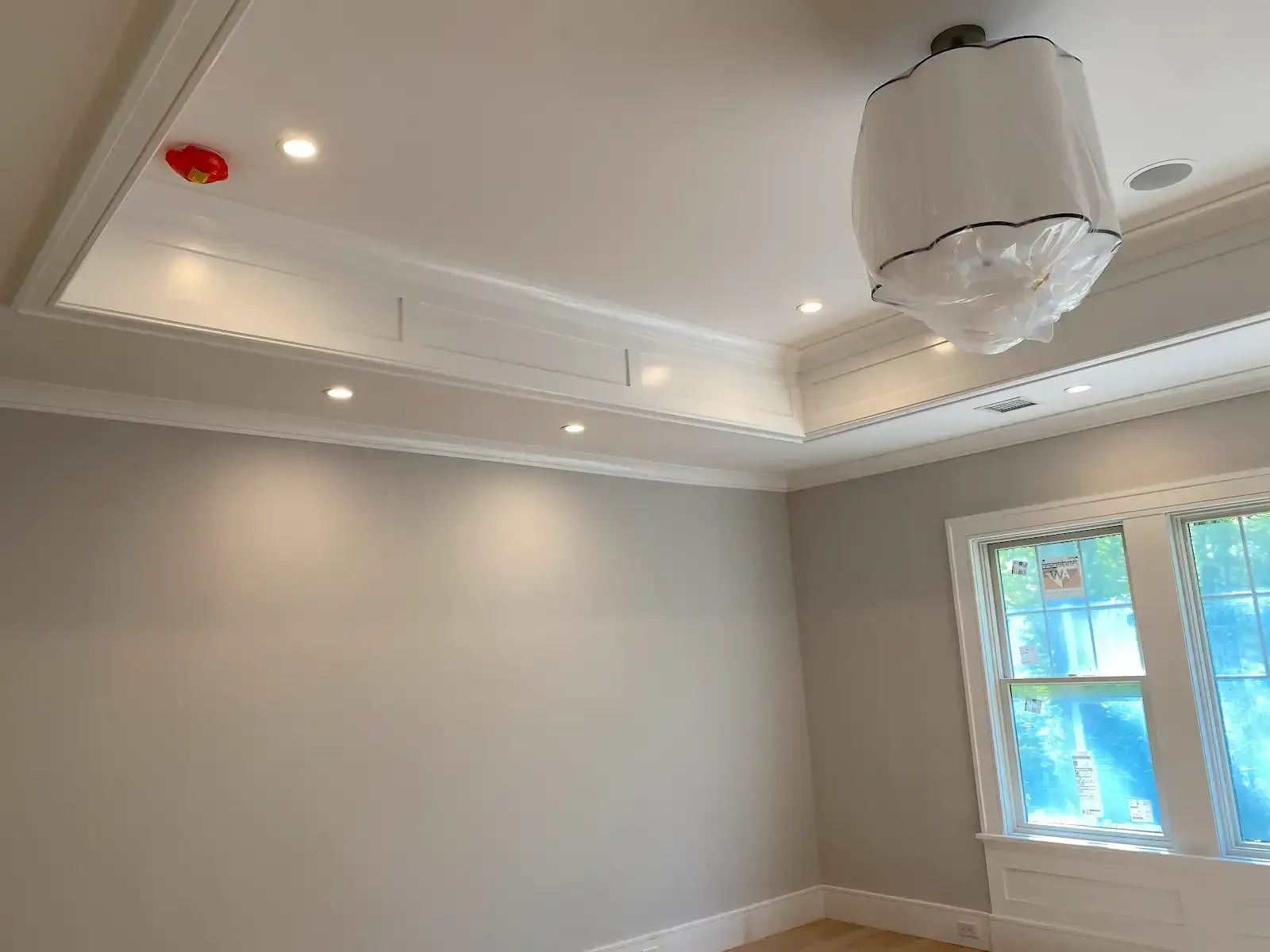 An empty room with a chandelier hanging from the ceiling