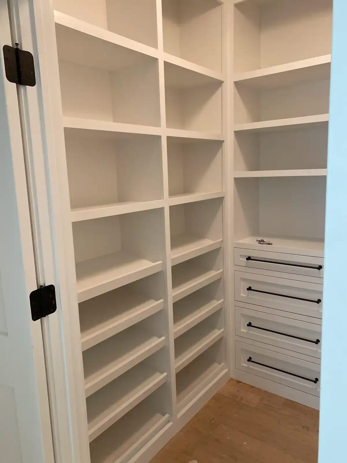 A walk in closet with lots of shelves and drawers