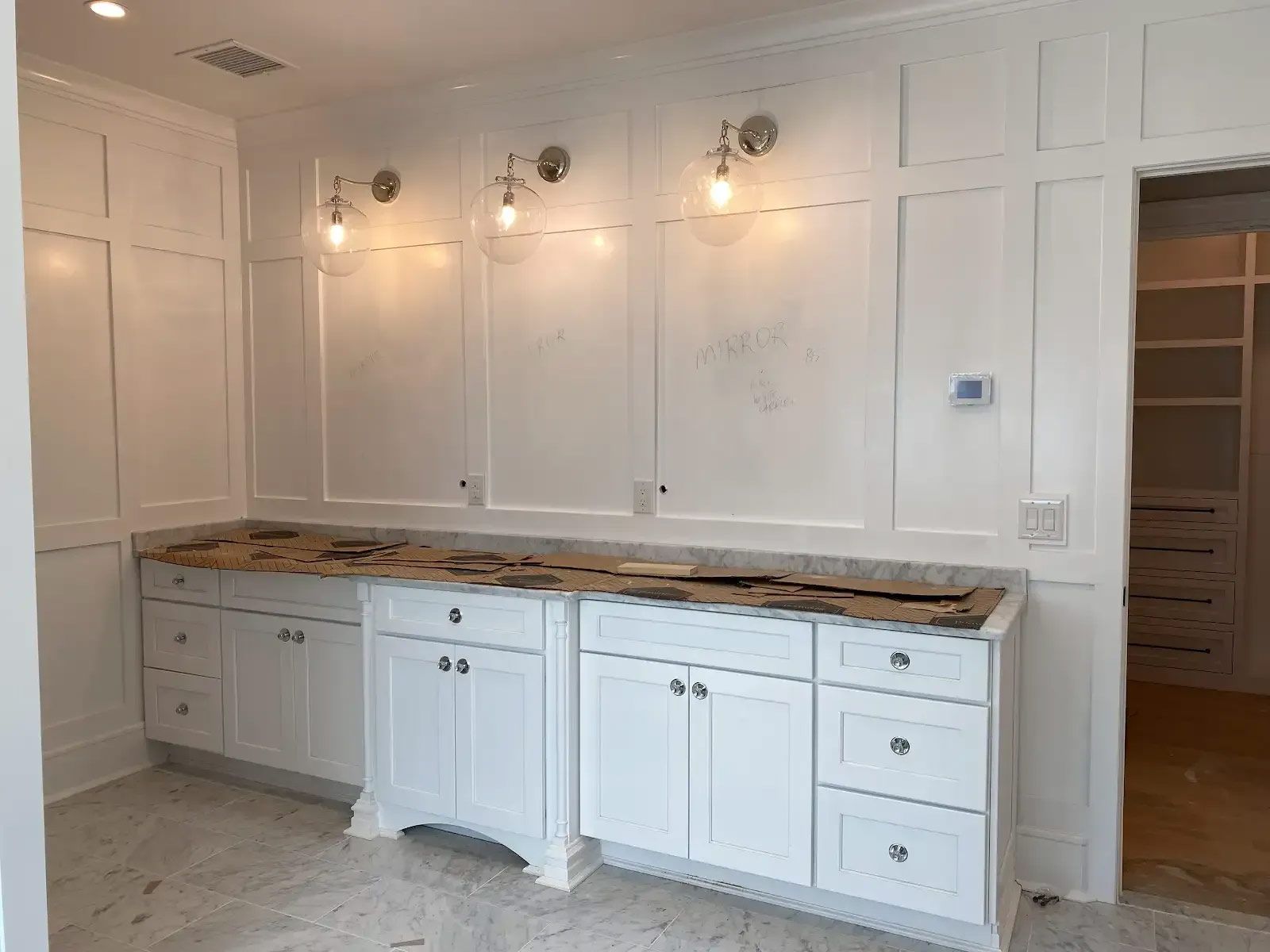 A bathroom with white cabinets and granite counter tops