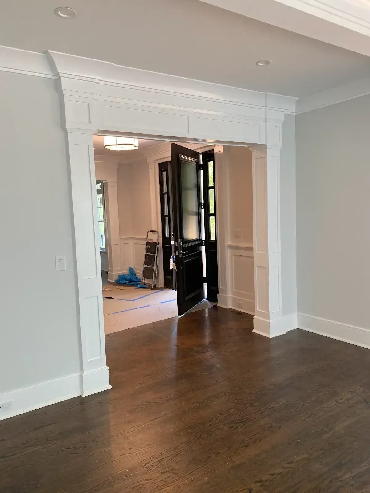 A living room with hardwood floors and a doorway leading to a hallway