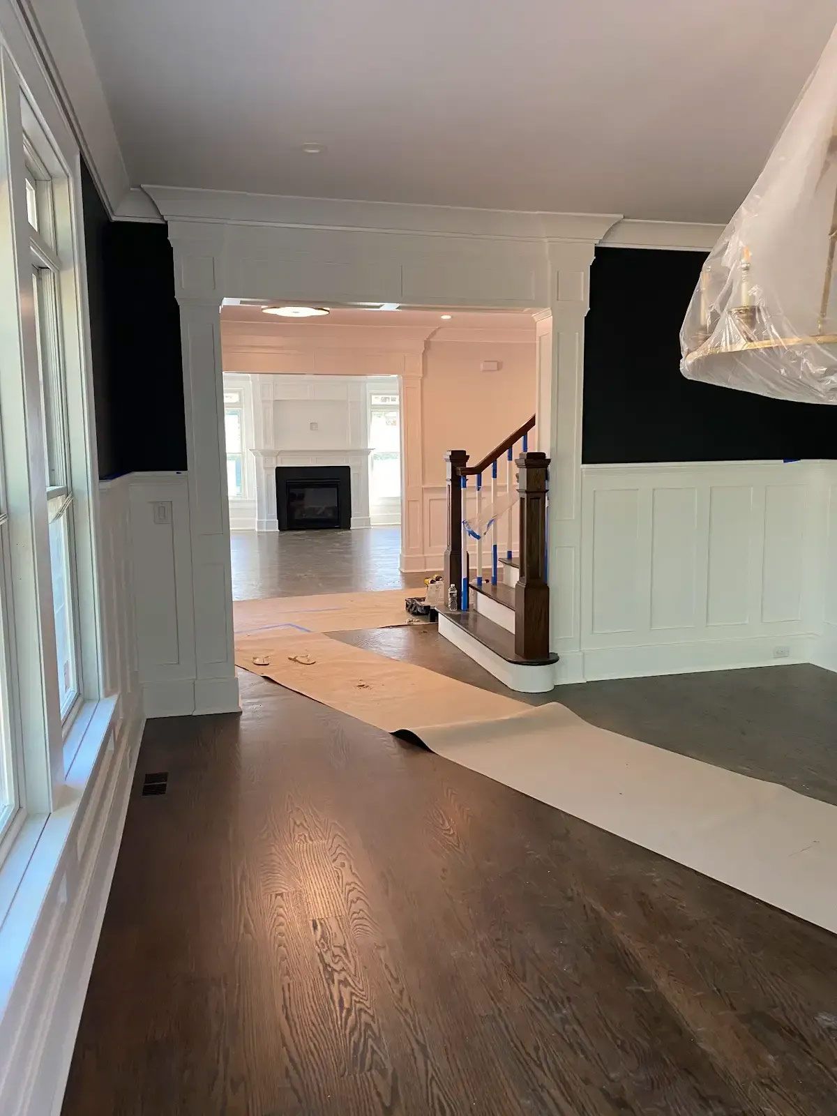 An empty room with a staircase and a fireplace in the background