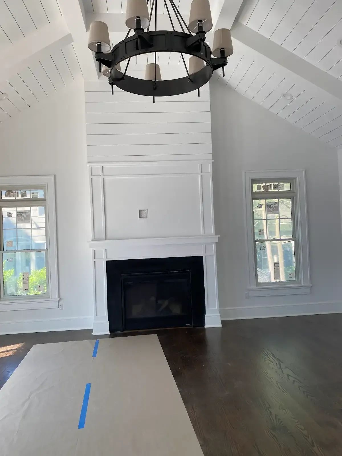An empty living room with a fireplace and a chandelier