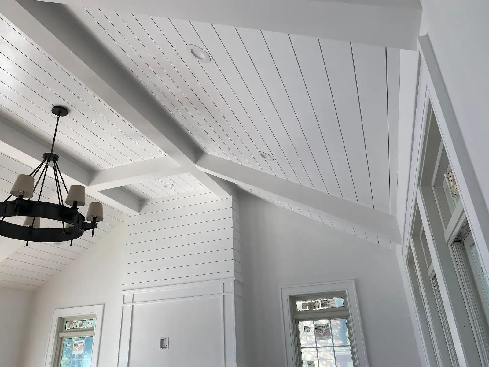 A white room with a chandelier hanging from the ceiling
