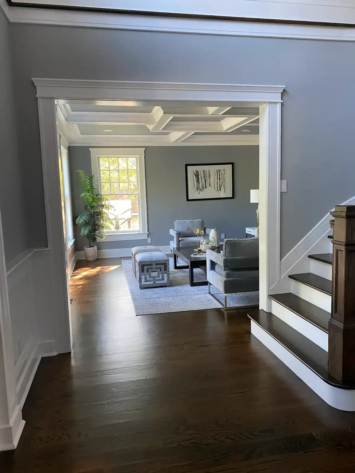 A living room with hardwood floors and stairs leading up to it