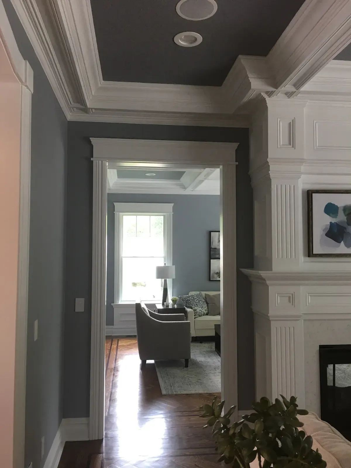 A hallway leading to a living room with a fireplace and a couch