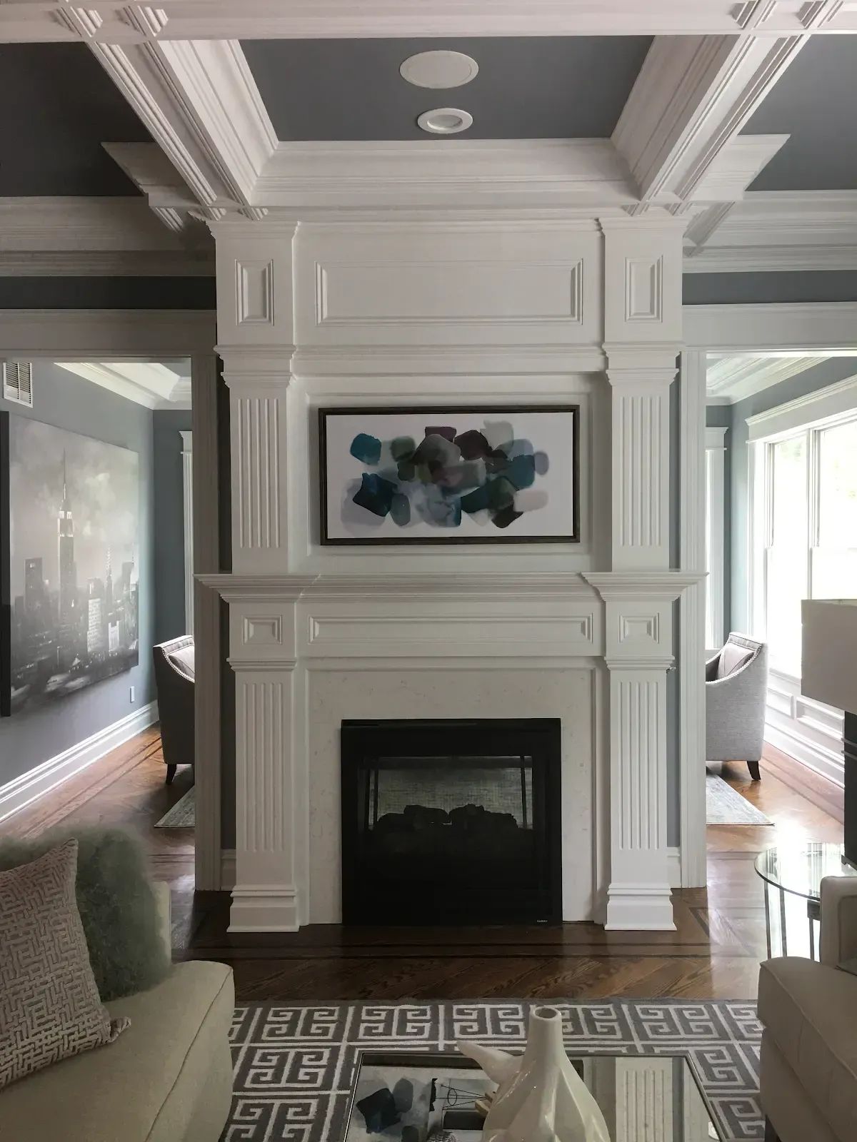 A living room with a fireplace and a painting on the wall