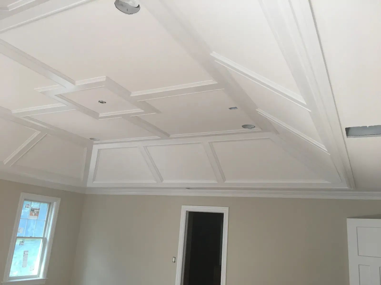 A room with a vaulted ceiling and a door