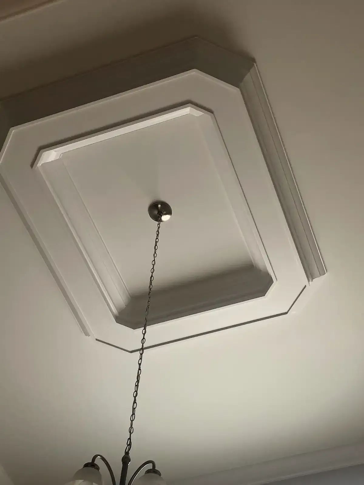 A chandelier is hanging from the ceiling of a room