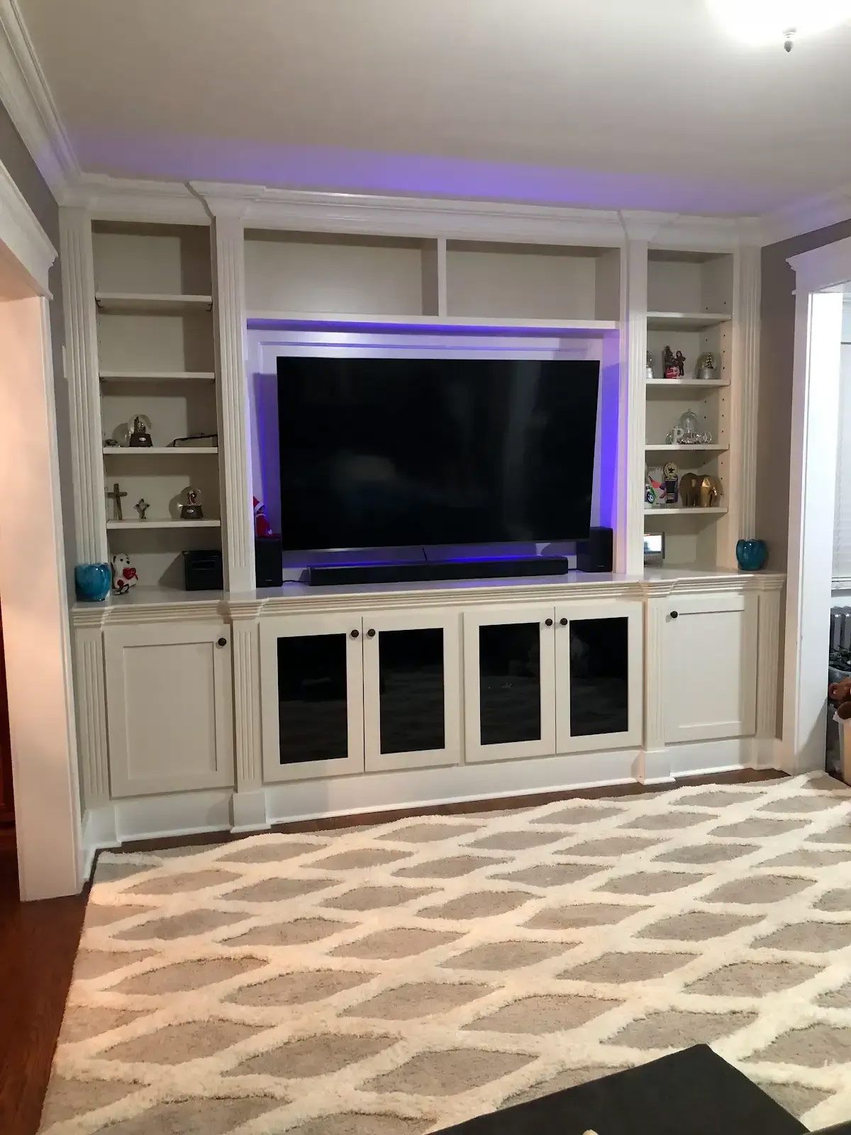 A living room with a large flat screen tv and a rug