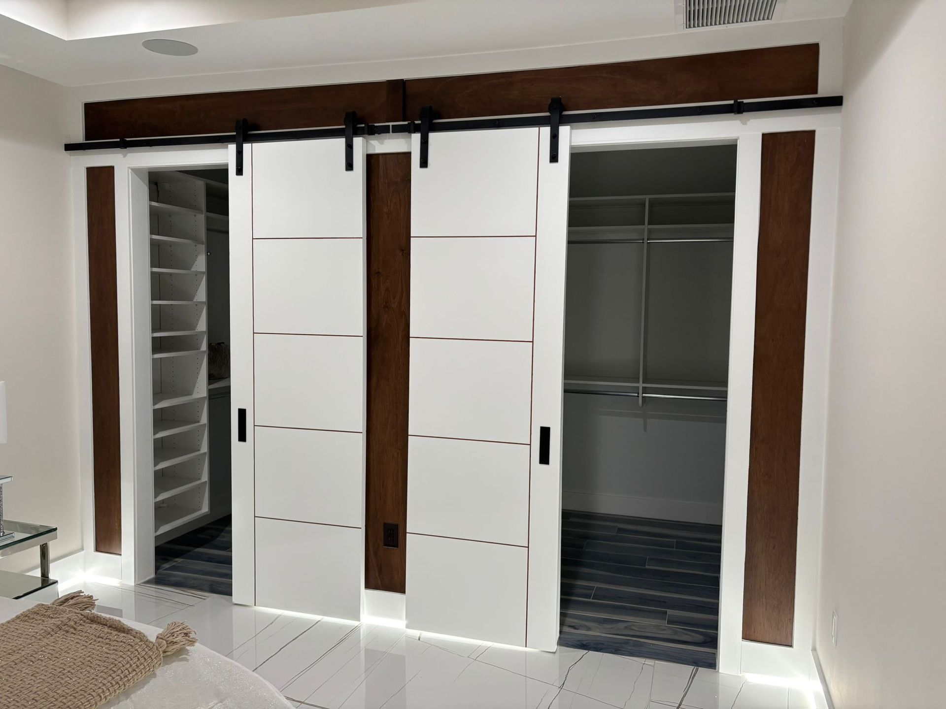 A bedroom with sliding barn doors leading to a walk in closet