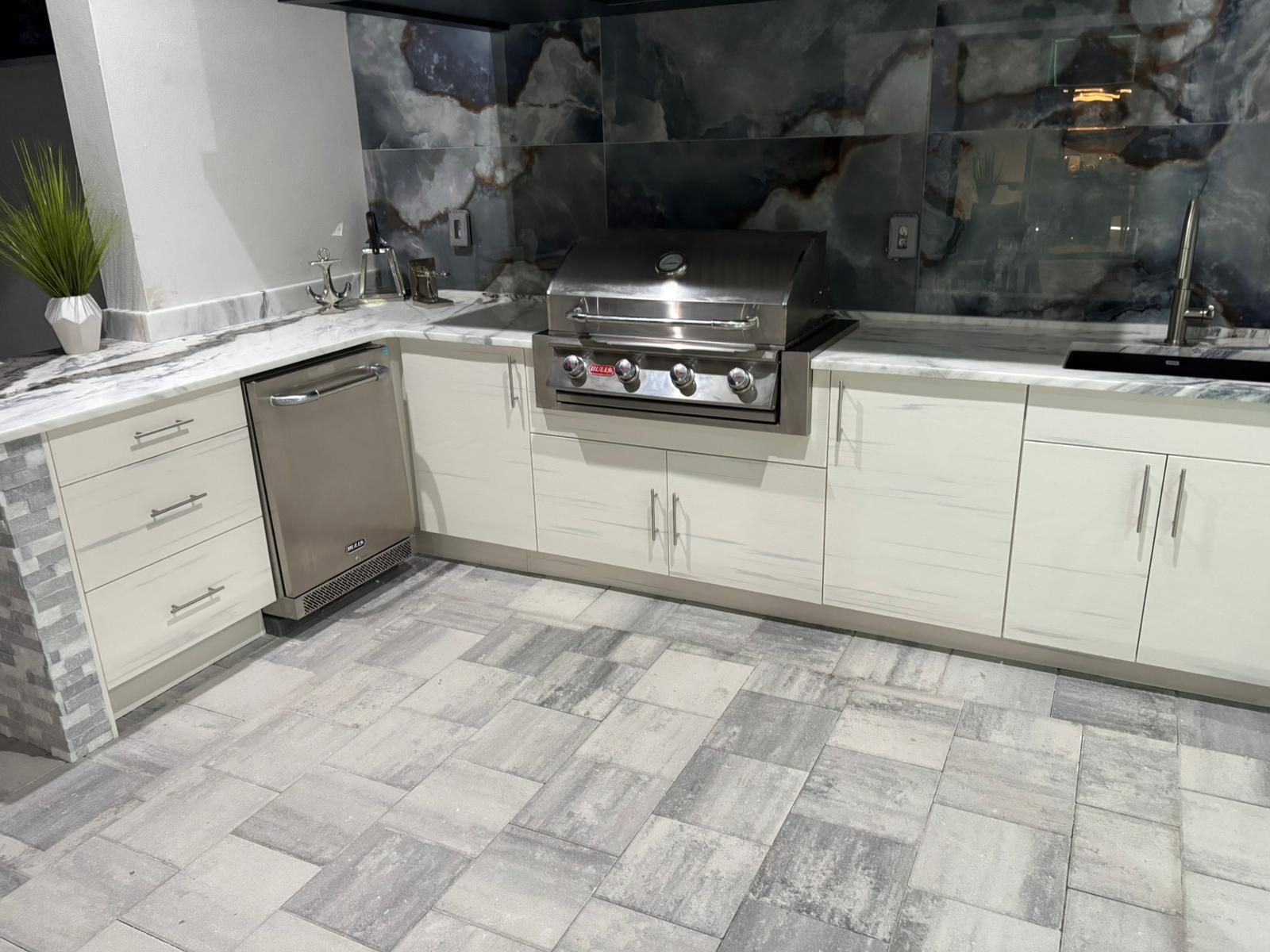 A kitchen with a grill, sink, and dishwasher