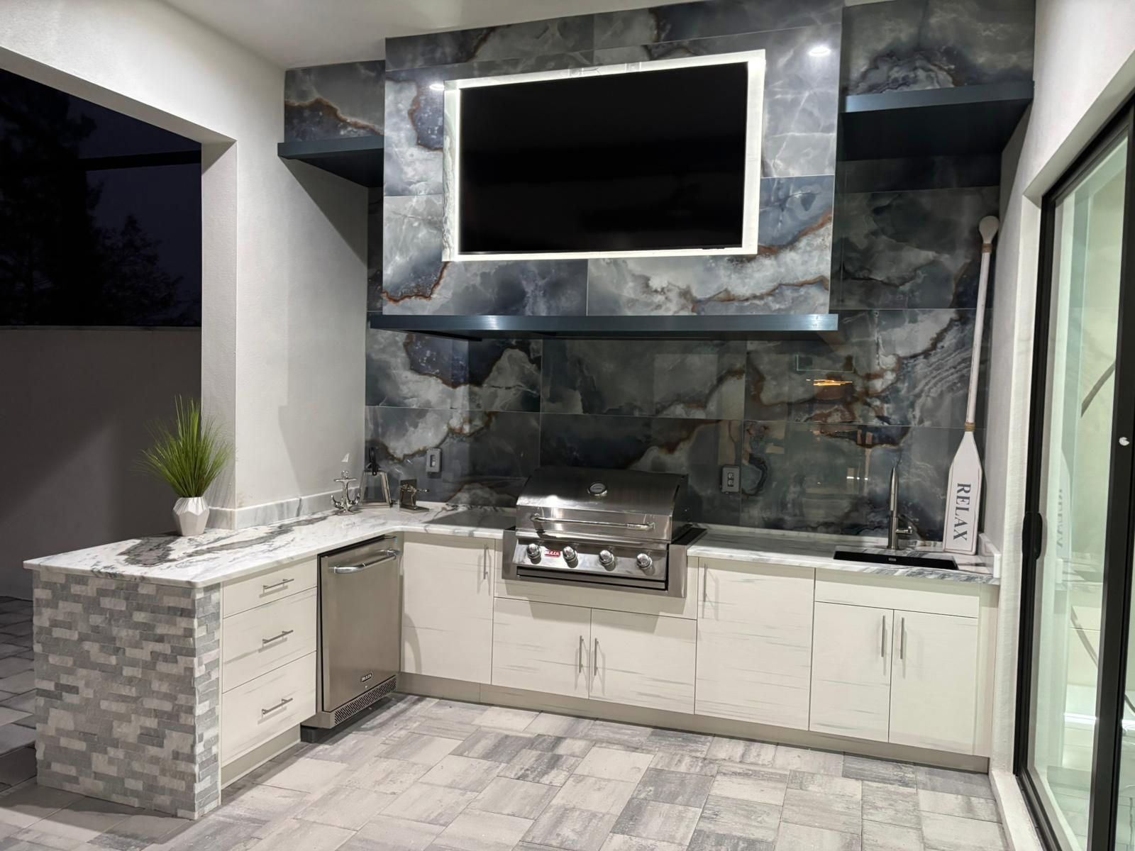 A kitchen with a grill and a flat screen tv on the wall