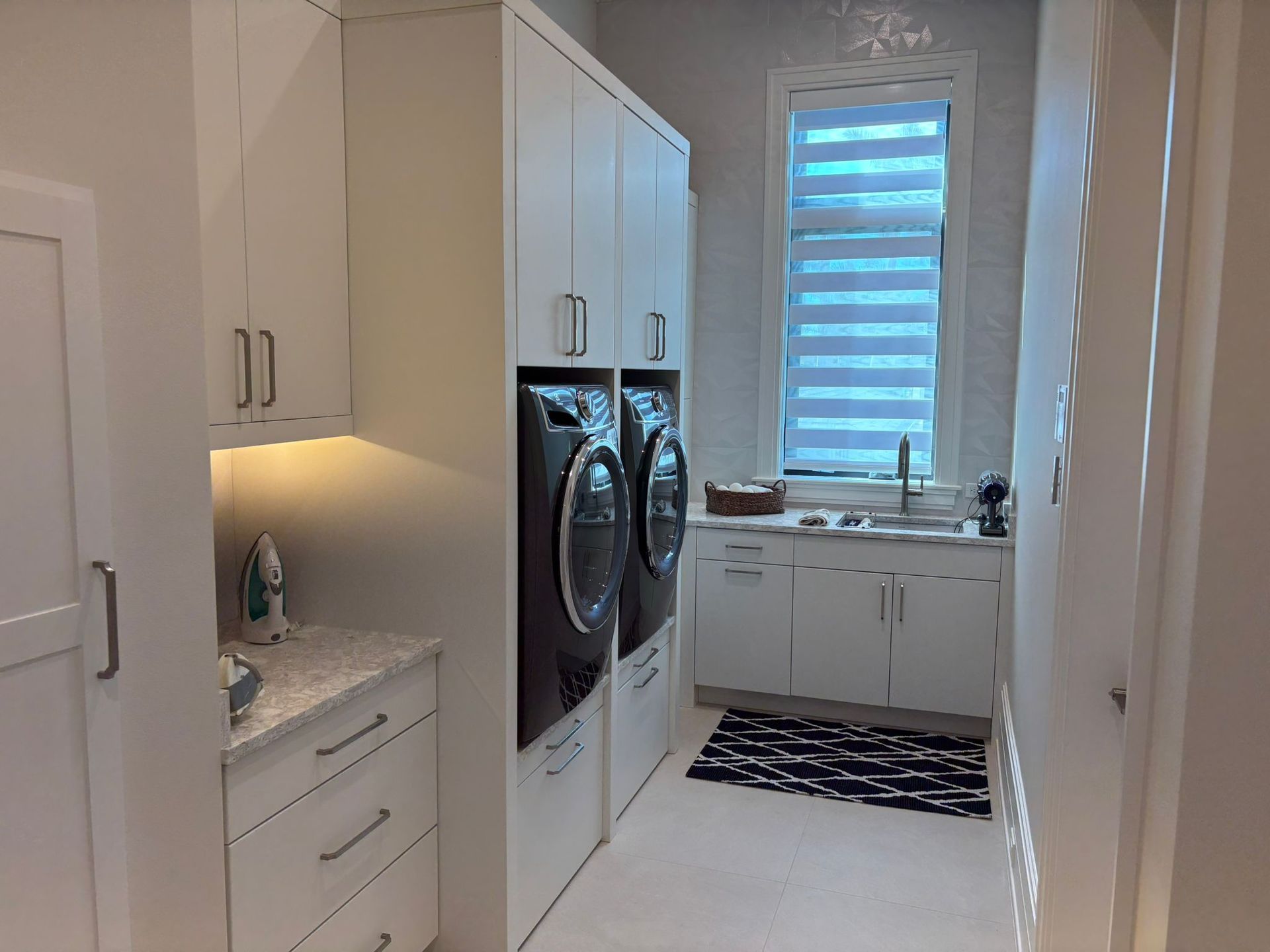 A laundry room with a washer and dryer and a window