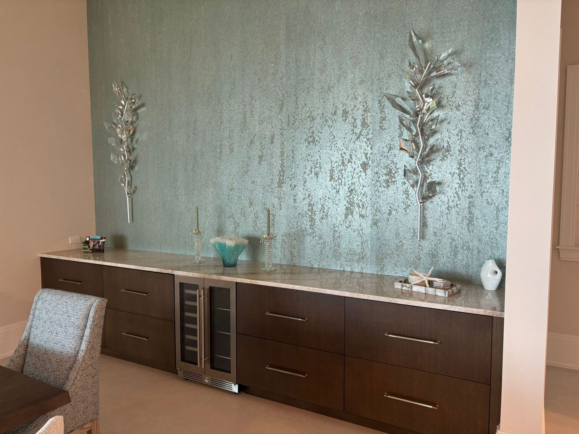 A dining room with a table and chairs and a wine cooler