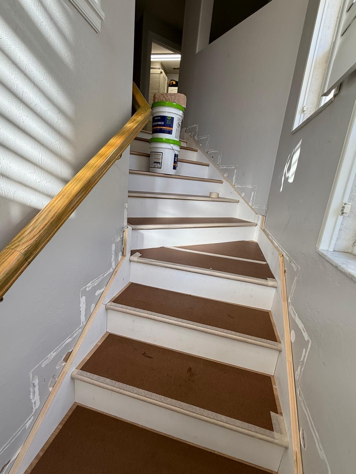 A bucket of paint is sitting on top of a set of stairs