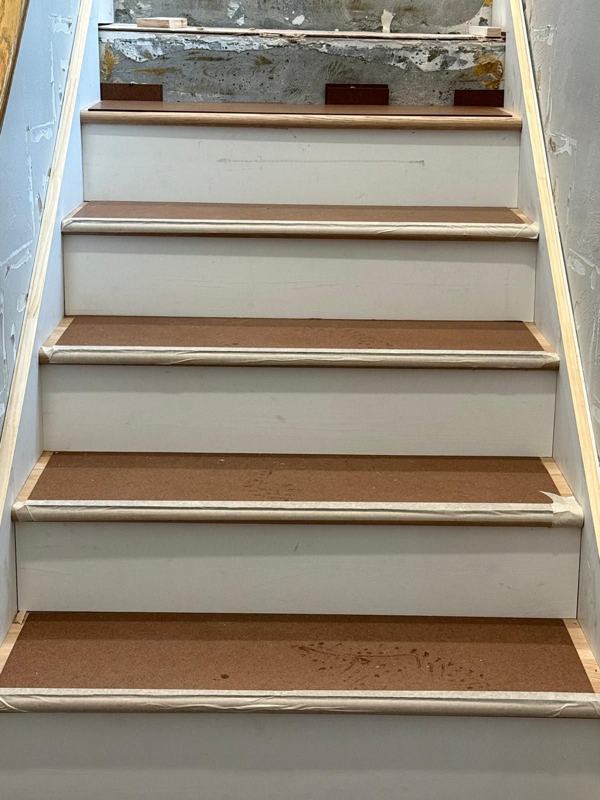 A set of white stairs with brown steps