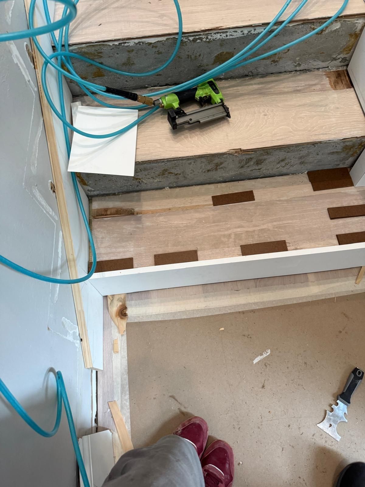 A person is standing next to a set of wooden stairs being built