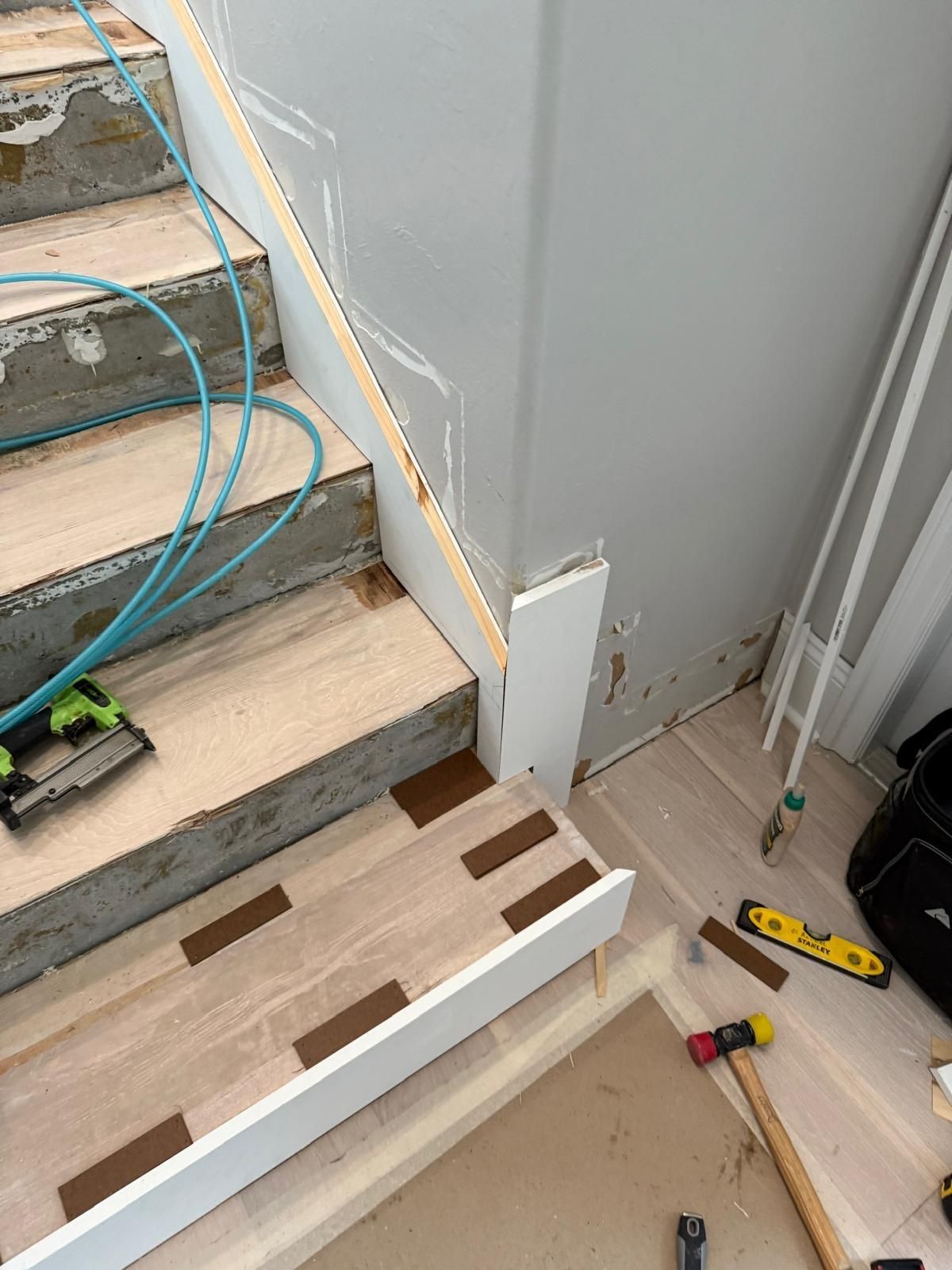 A wooden staircase is being built in a house