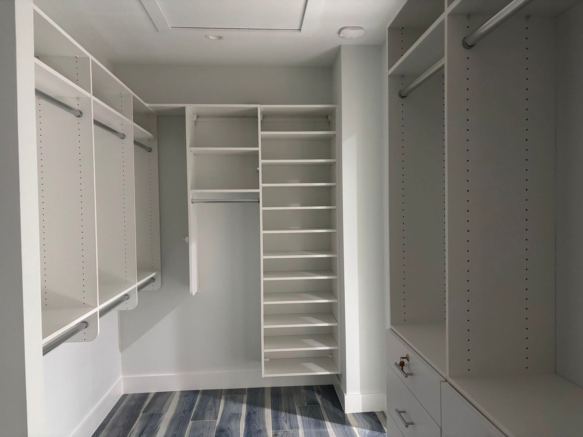 A walk in closet with lots of shelves and drawers