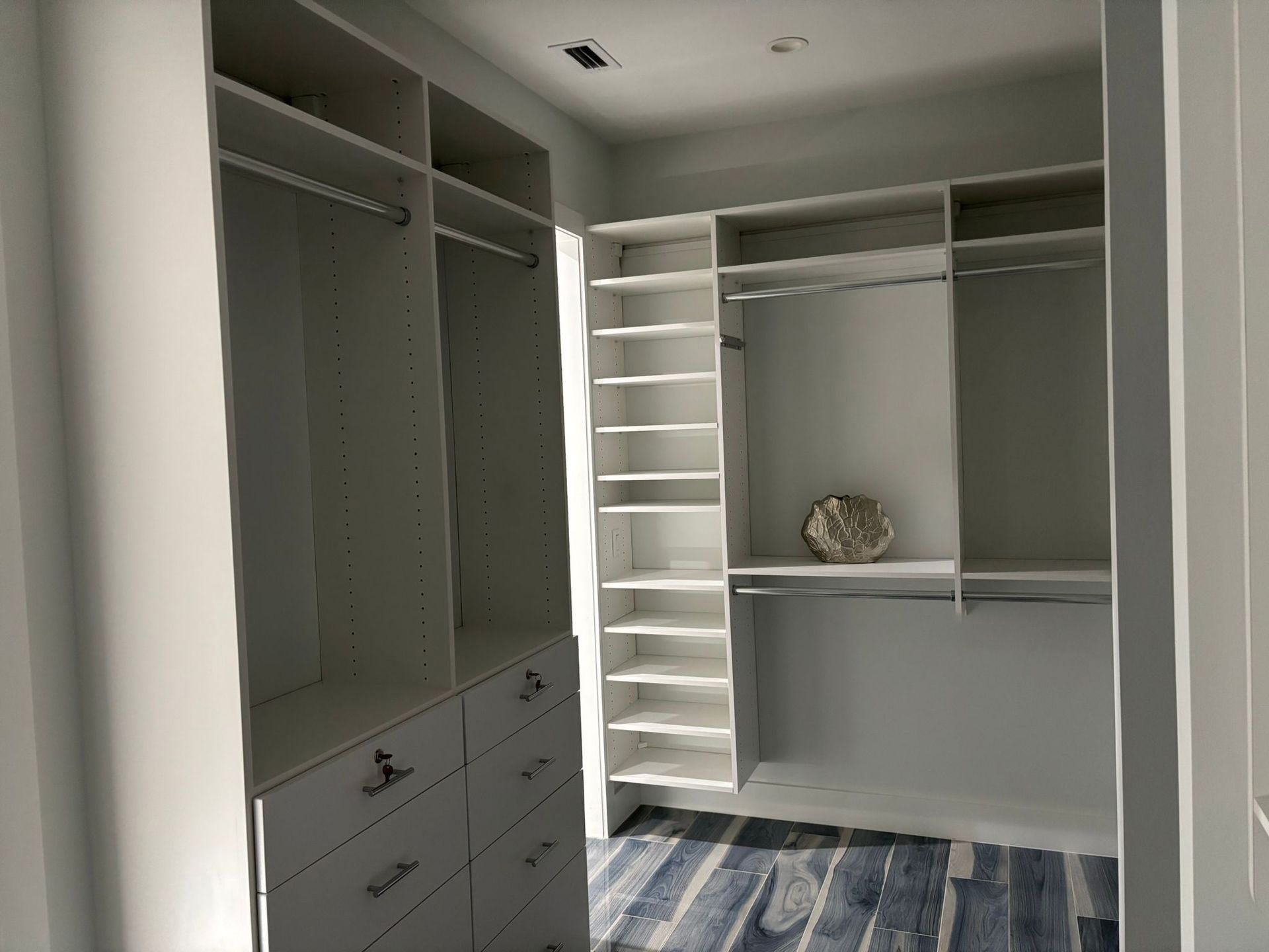 A walk in closet with lots of shelves and drawers