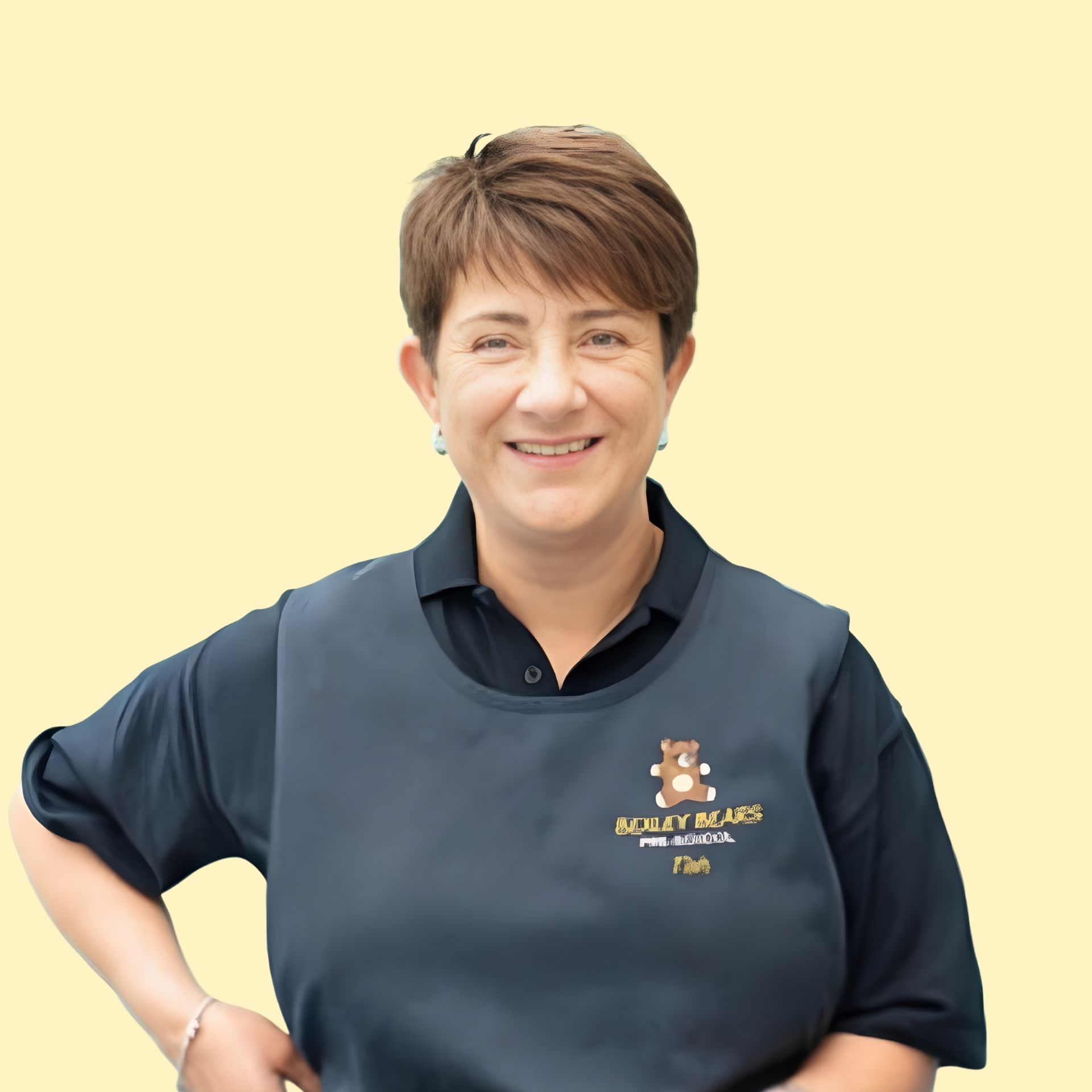 Smiling person with curly dark hair and light skin, against a yellow background.