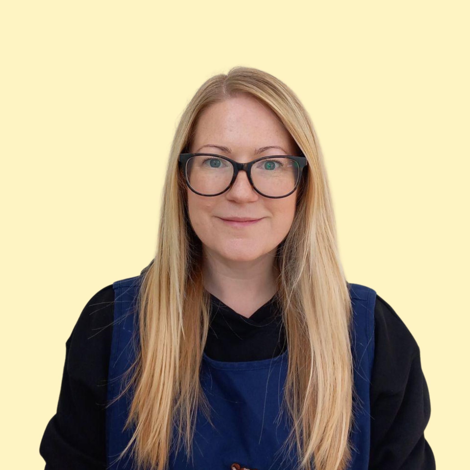 Woman with long dark hair smiles widely, wearing a striped shirt against a yellow background.