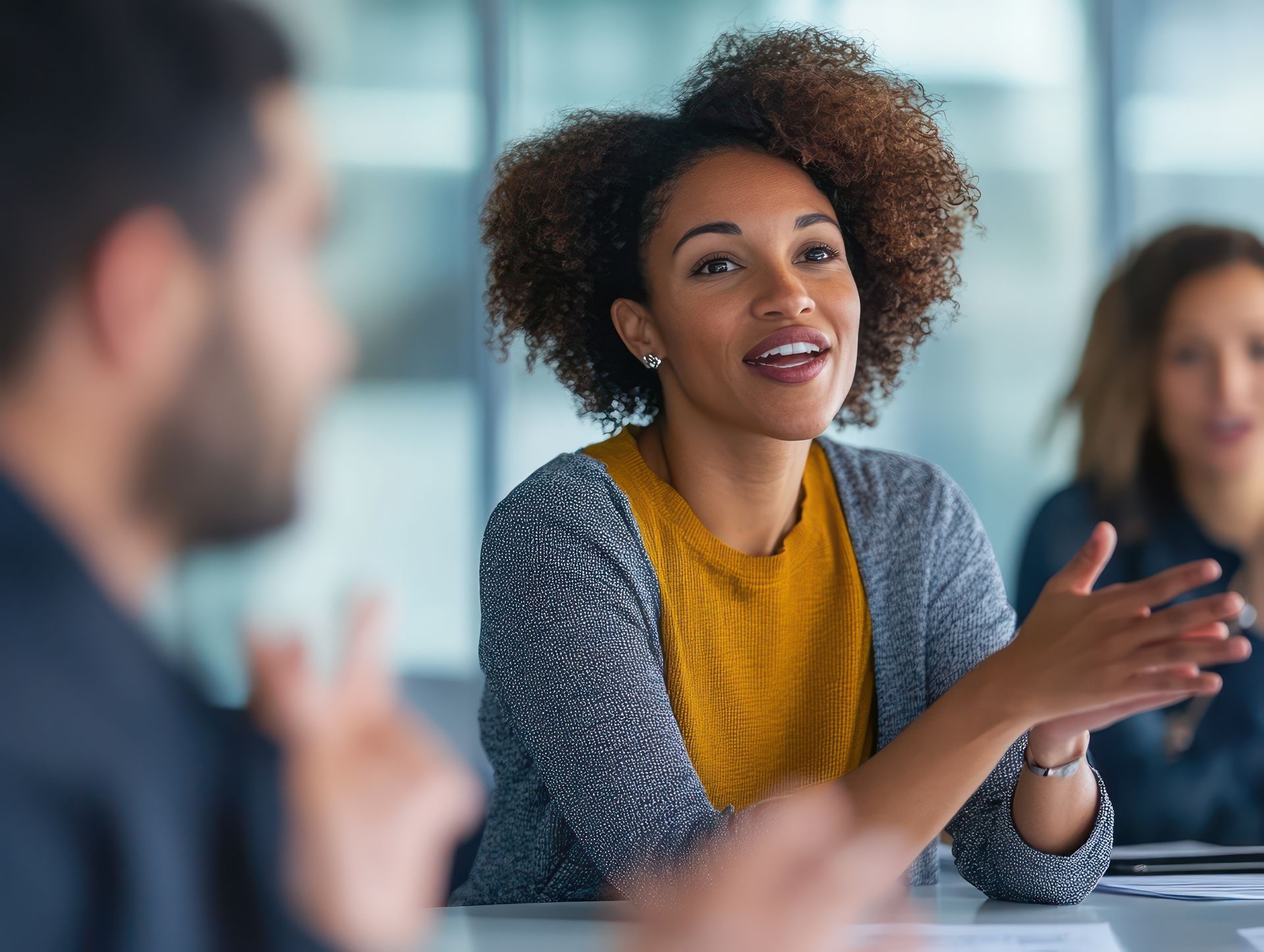 leadmonkey.ai | A woman is sitting at a table talking to a group of people.