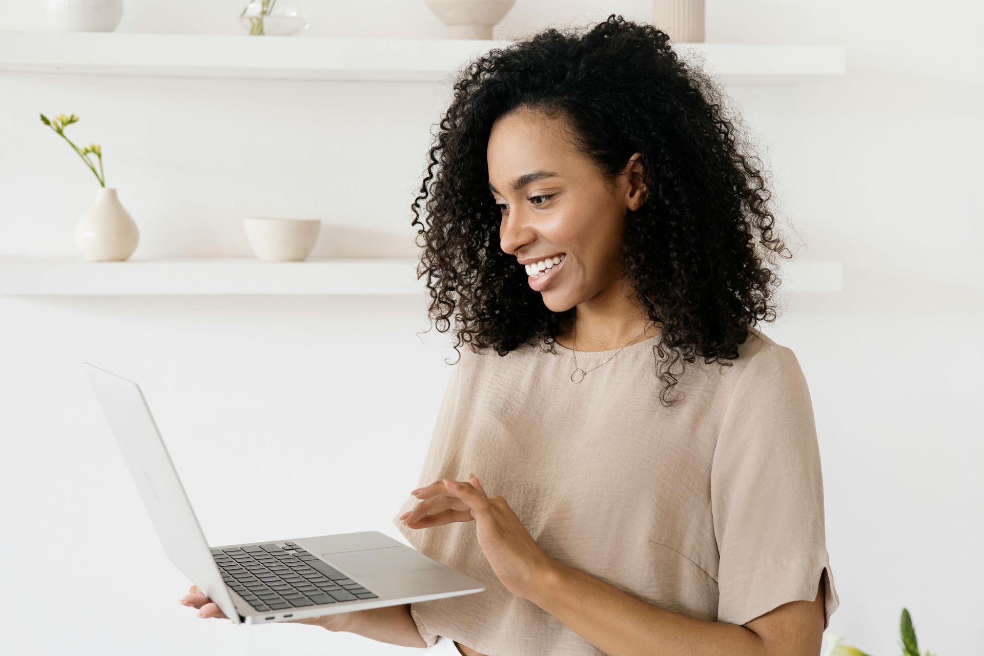 leadmonkey.ai | A woman is holding a laptop computer in her hands and smiling.