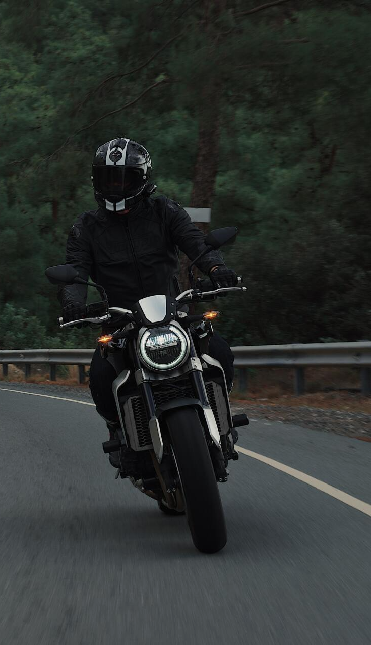 A man is riding a motorcycle down a road.