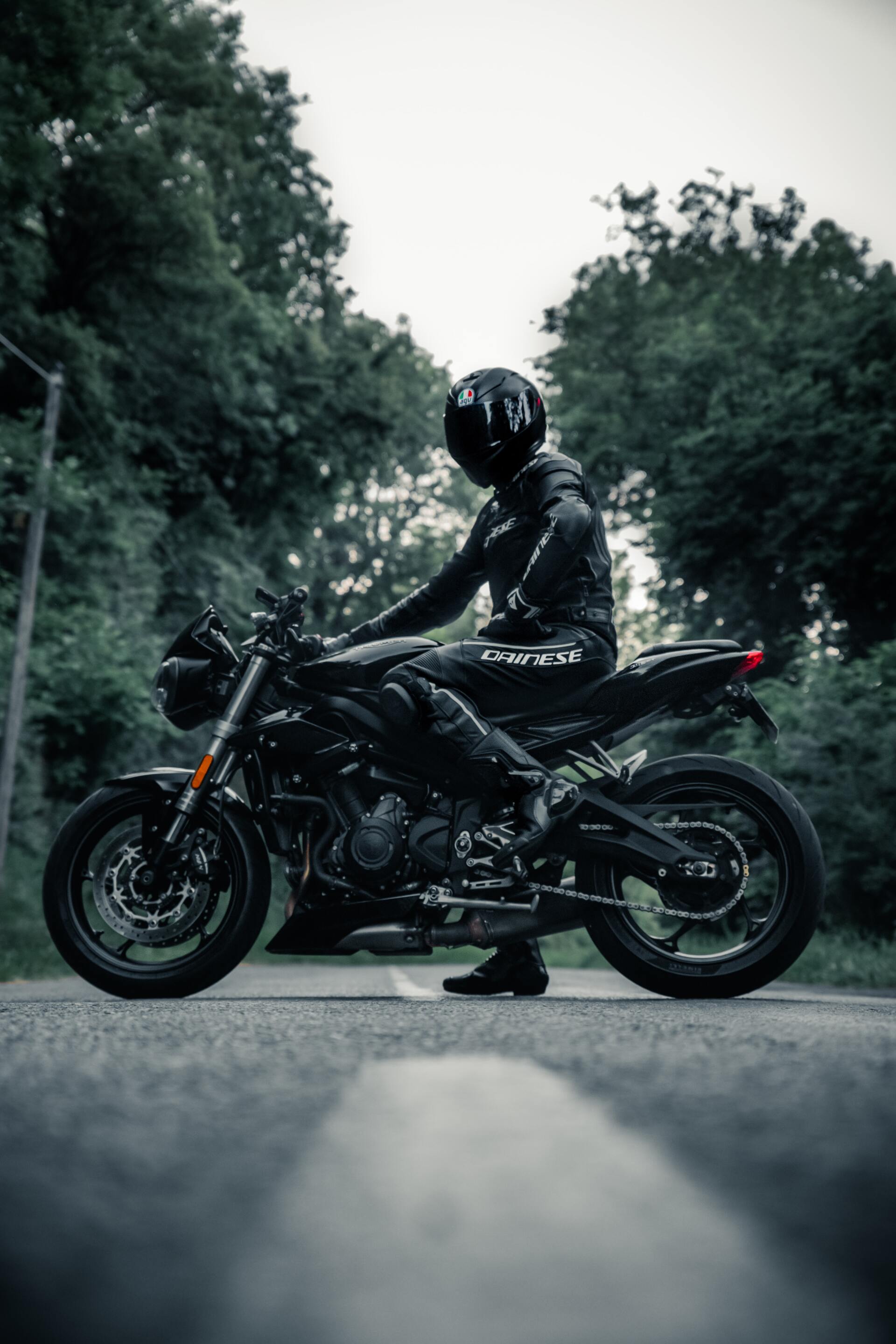 A man is riding a motorcycle down a road.