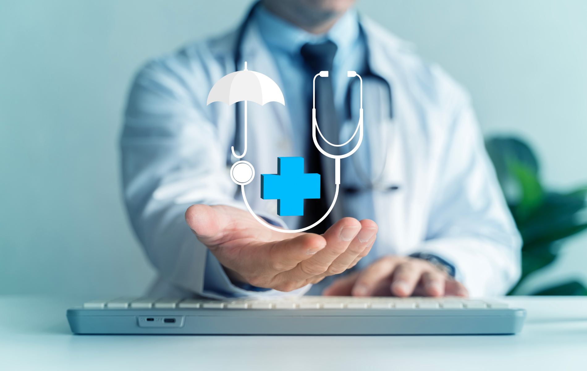 A doctor in a white coat holding a glowing medical insurance and stethoscope icon over a keyboard.