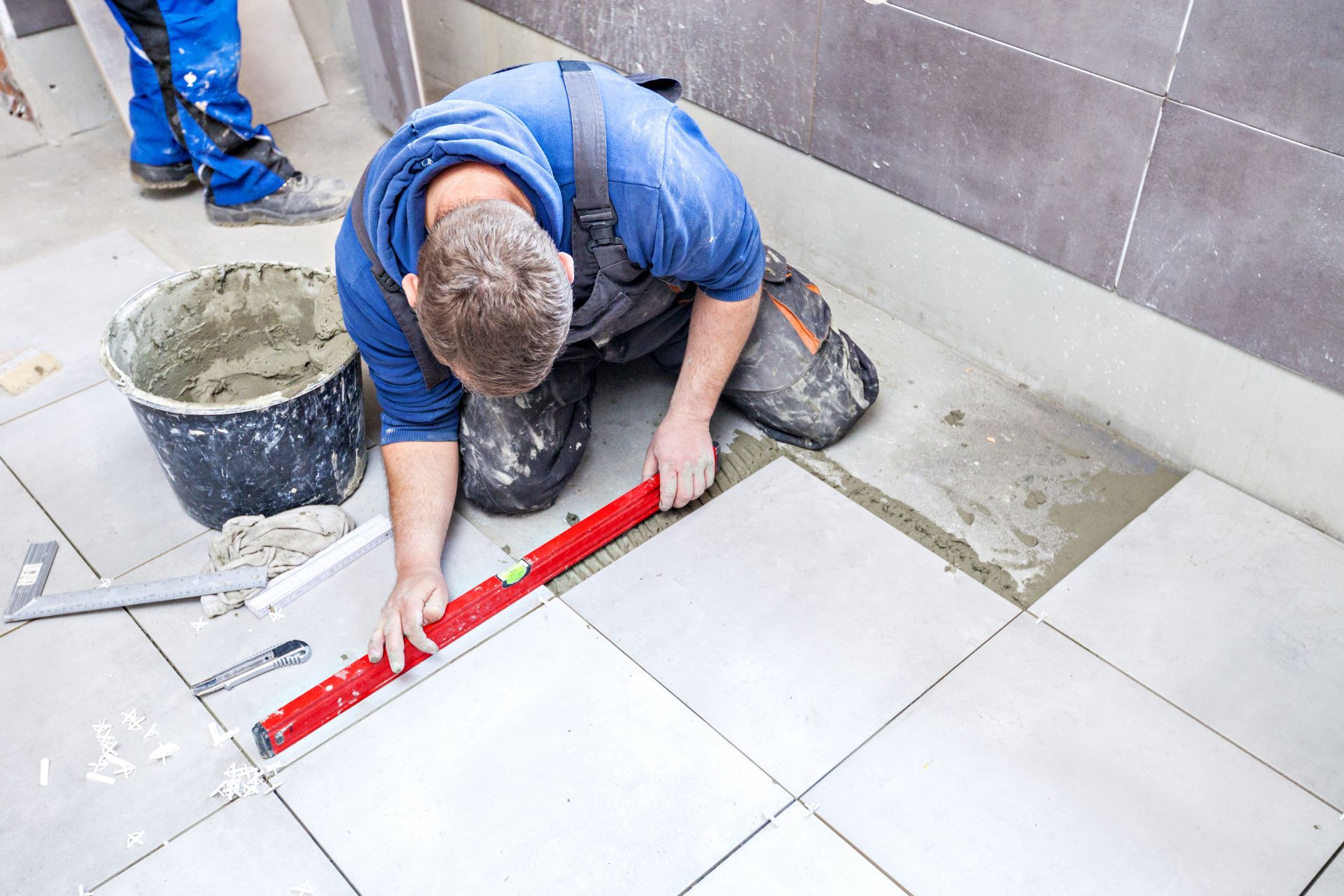 Worker measuring flooring tiles