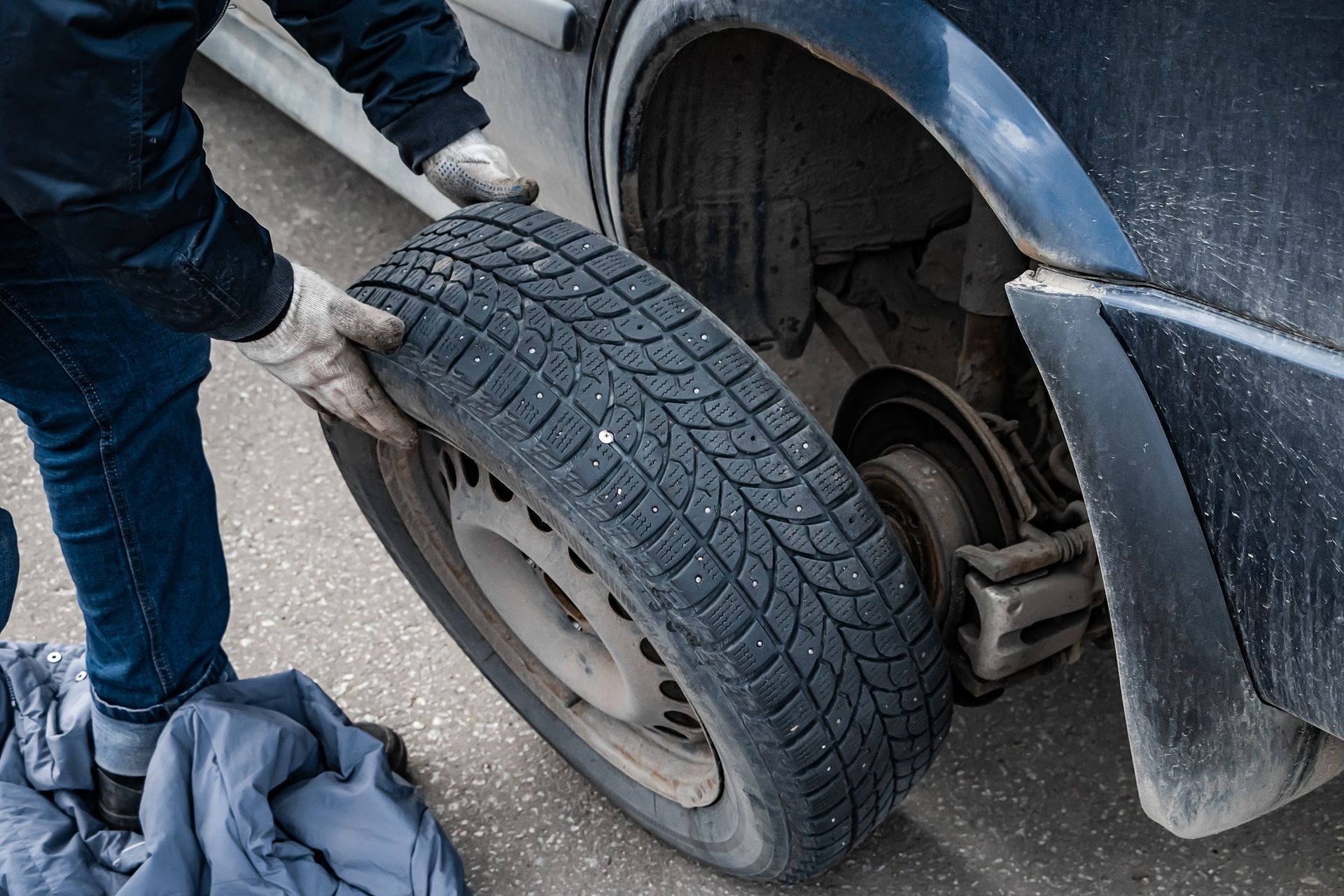 A man is changing a tire on a car.