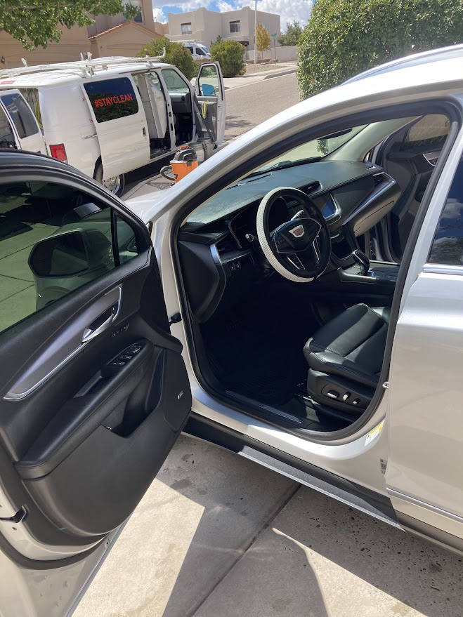 The inside of a silver car with the door open