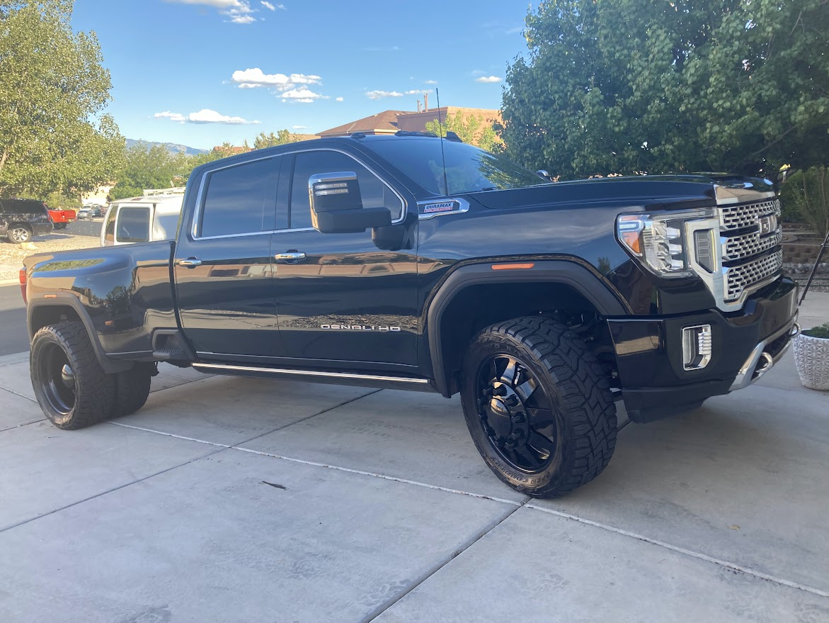 A black pickup truck is parked in a driveway.