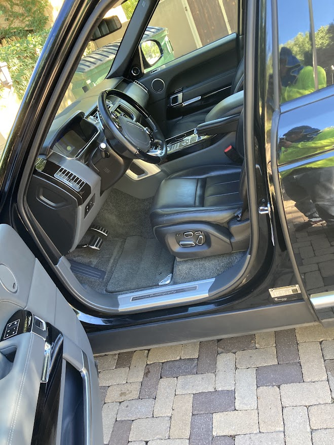 The inside of a black range rover with the door open