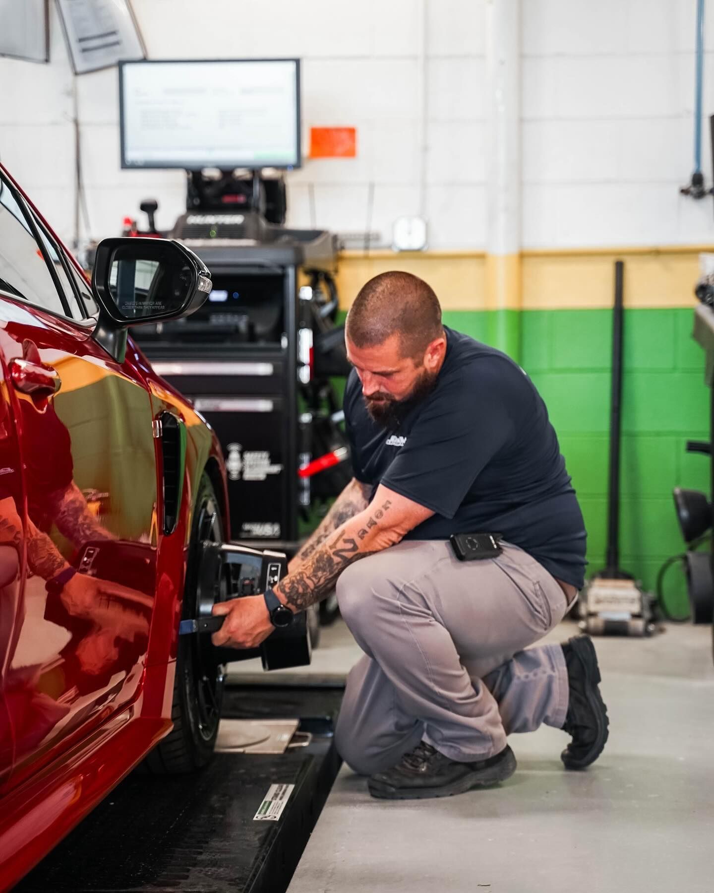 Mechanic Working On Red Car Wheel Alignment | D&V Autobody Overland