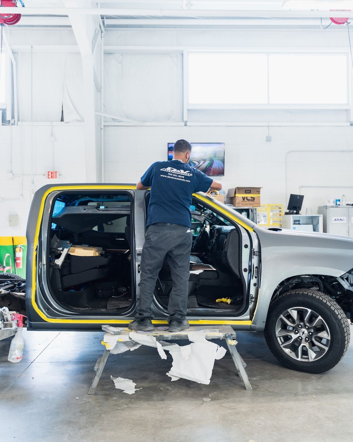 Mechanic Working On Black SUV Door Panel | D&V Autobody Overland
