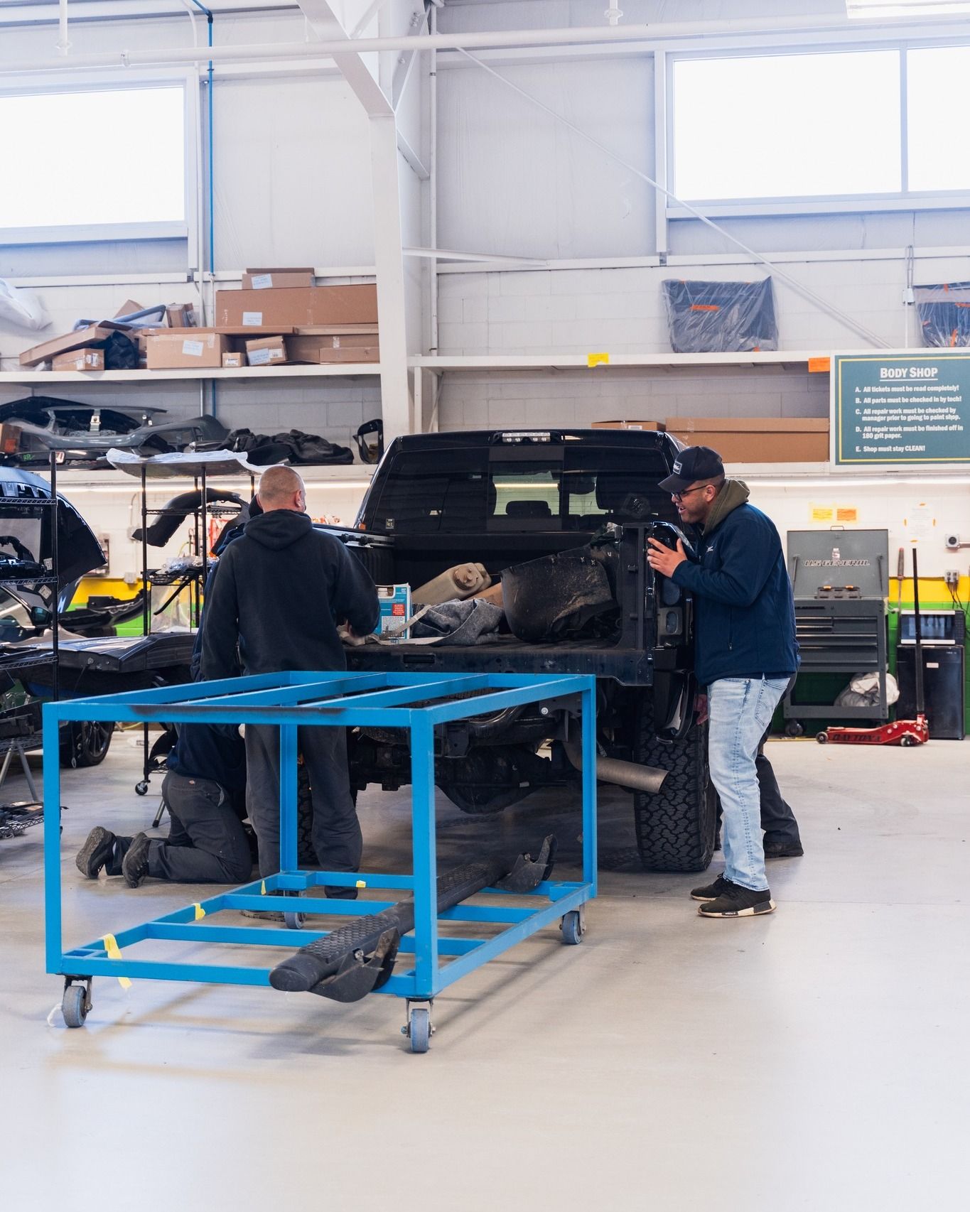 Technician Repairing Black Car In Auto Shop | D&V Autobody Overland