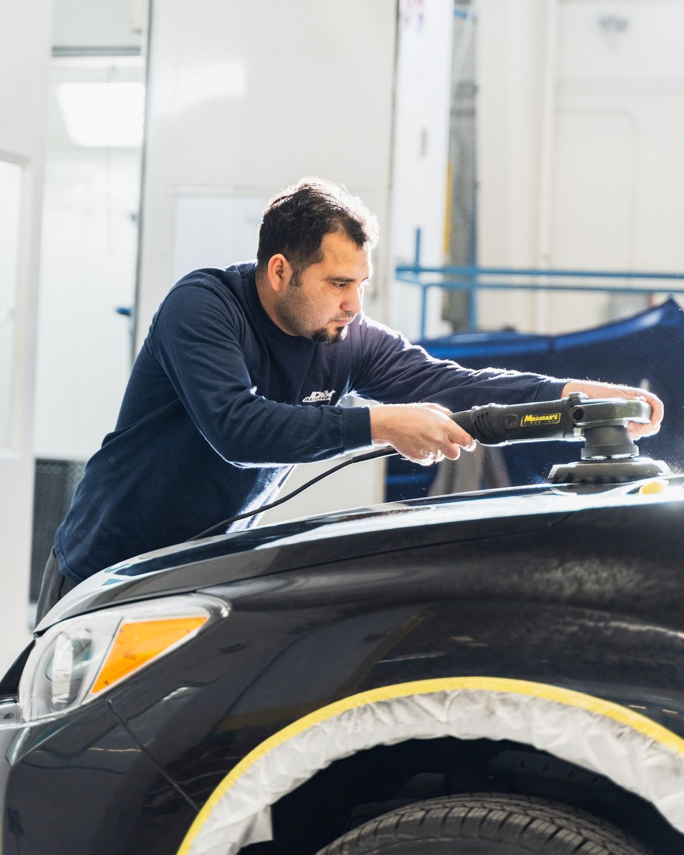 Technician Polishing Black SUV In Auto Shop | D&V Autobody Overland