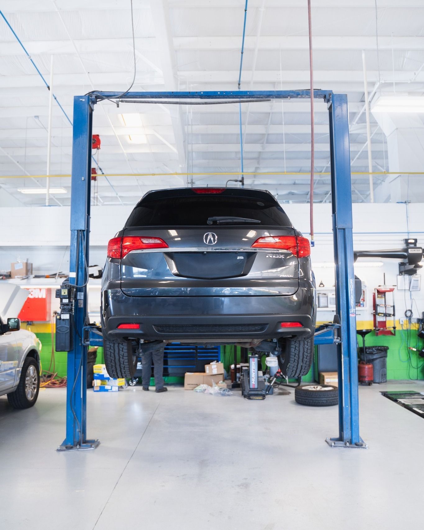 Black Car On Lift For Undercarriage Inspection | D&V Autobody Overland