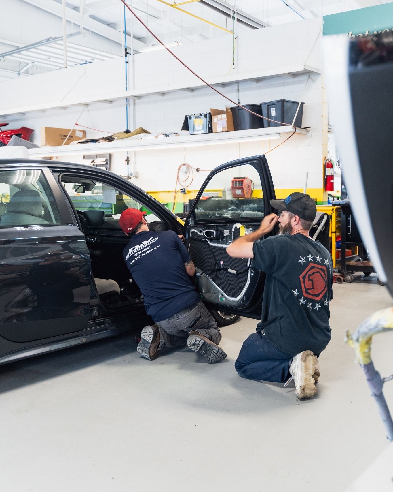 Mechanic Working On Black Car Tire In Shop | D&V Autobody Overland
