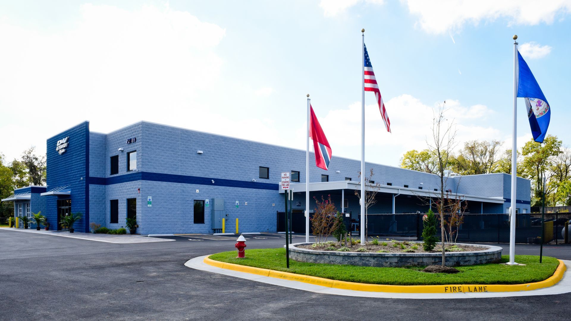 D&V Autobody Exterior With Flags At Front Entrance | D&V Autobody