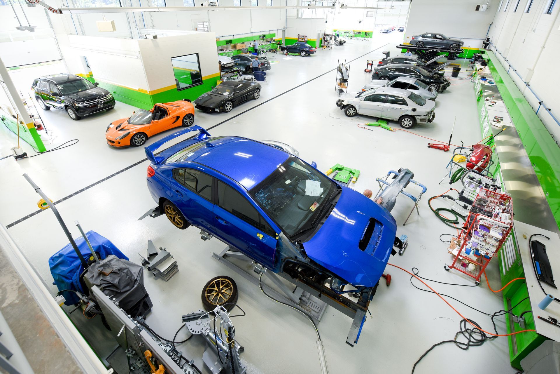 Blue Car Positioned Inside Auto Body Facility | D&V Autobody