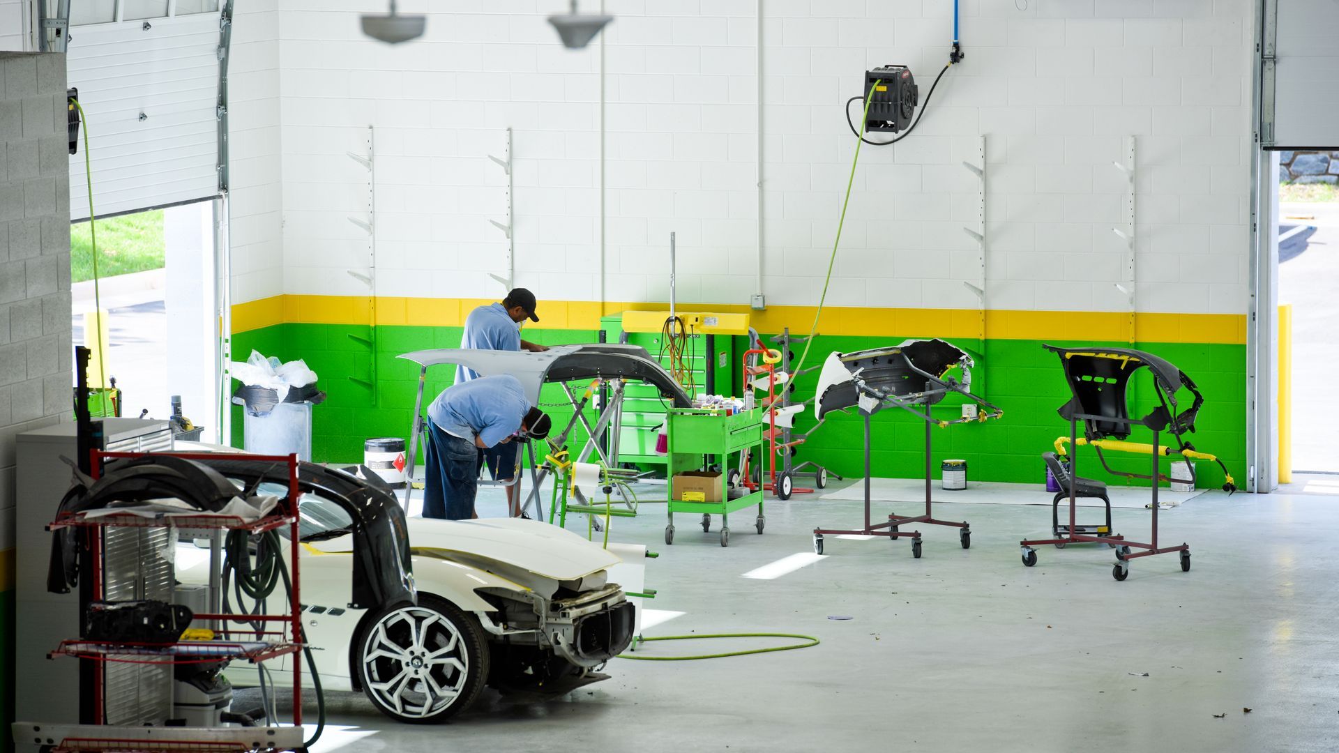 Technician Working On Silver Vehicle In Shop | D&V Autobody