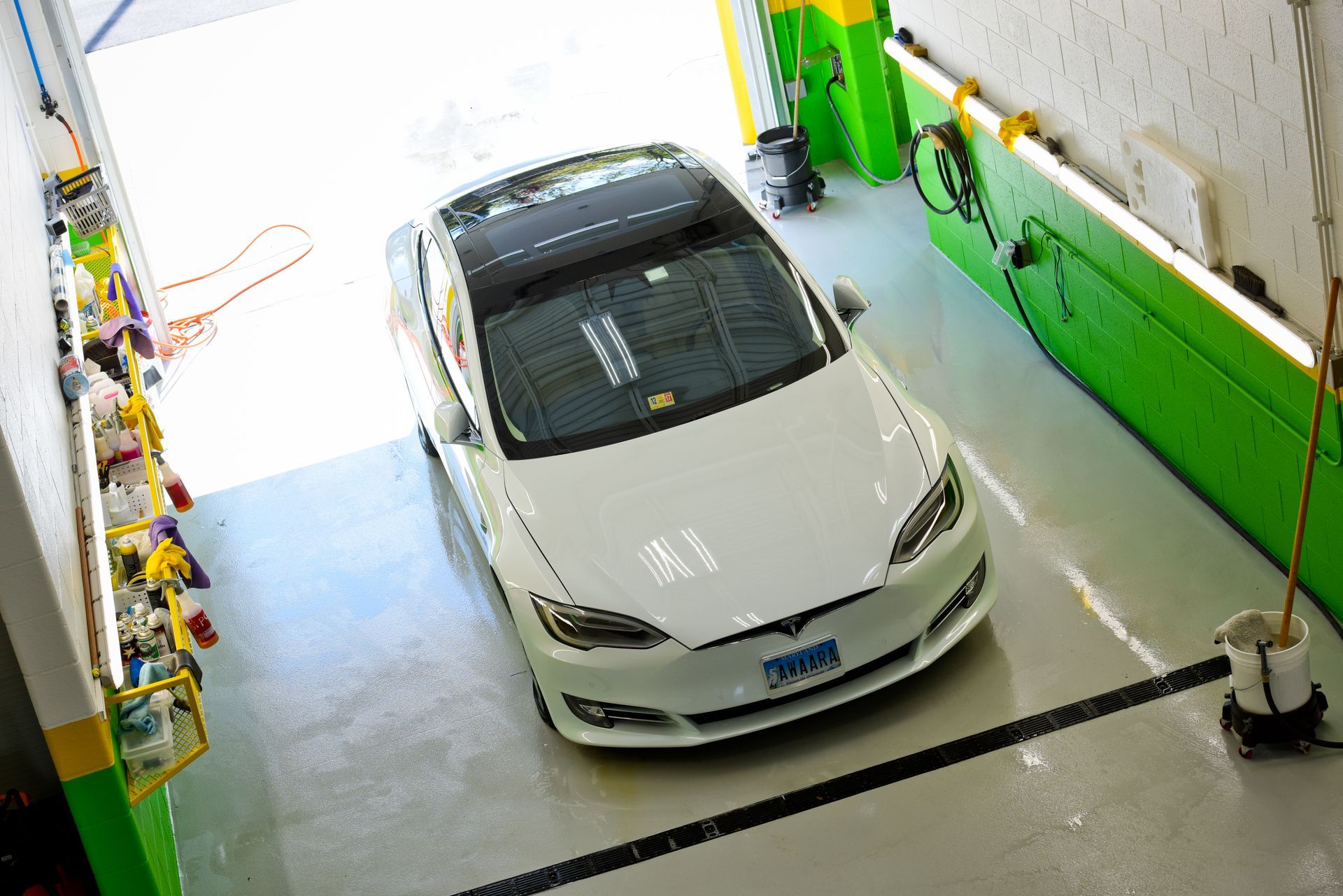White Car Parked Inside Green And White Auto Shop | D&V Autobody Masters