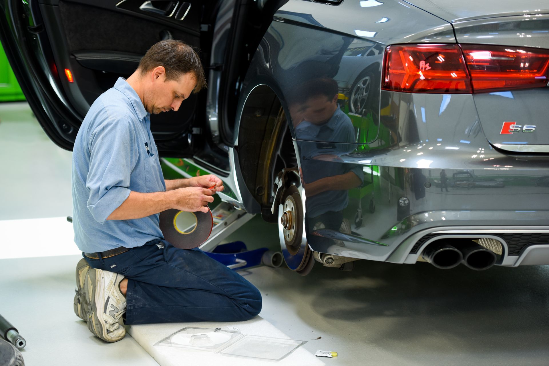 Technician Inspecting Rear Wheel Of Silver Car | D&V Autobody