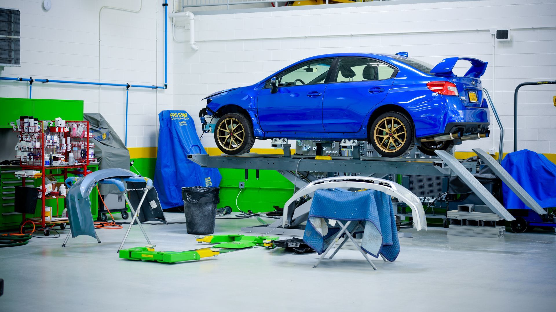 Blue Car On Lift In Service Bay With Tools | D&V Autobody Masters