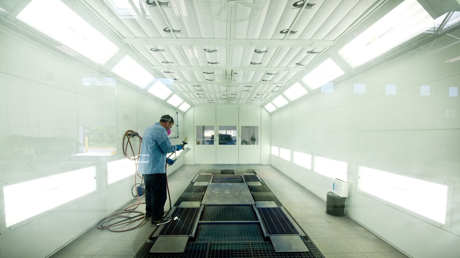 Technician Spraying Paint Inside Large Booth | D&V Autobody
